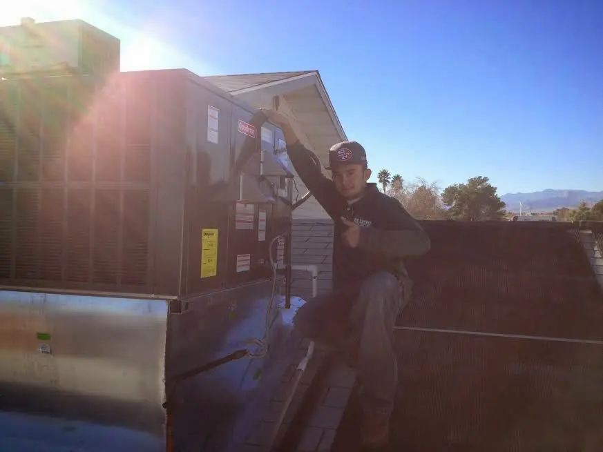 HVAC technician performing Air Duct Cleaning on a rooftop unit in Toppenish